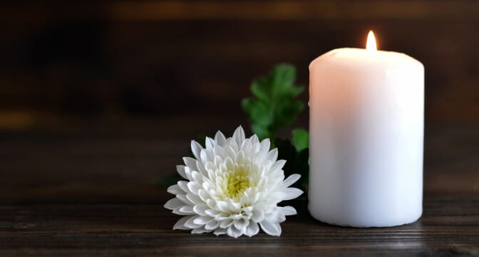 http://A%20white%20flower%20next%20to%20a%20lit%20white%20candle