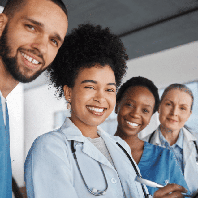 Four healthcare providers of different ethnicities smiling