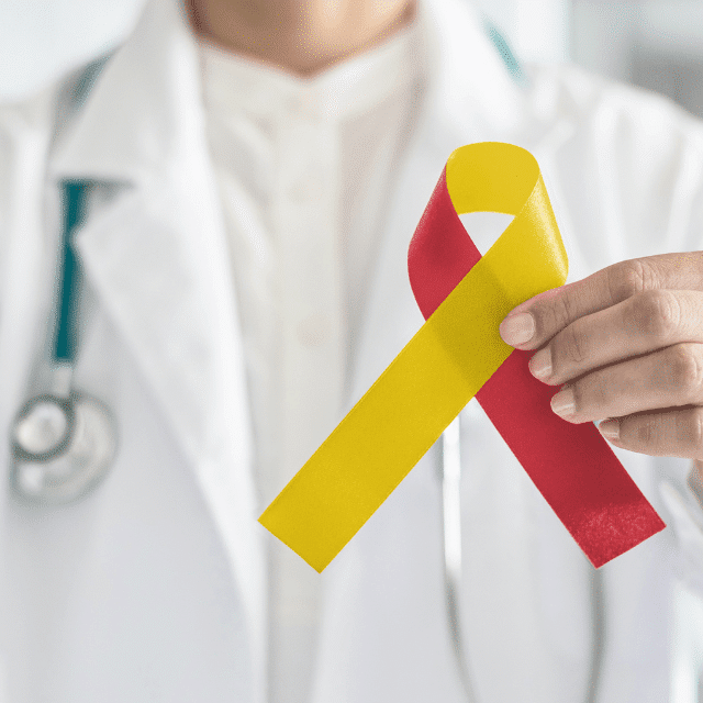 Healthcare provider holding a red and yellow ribbon in their hand