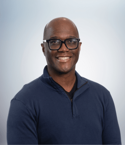 headshot of a man on light blue background