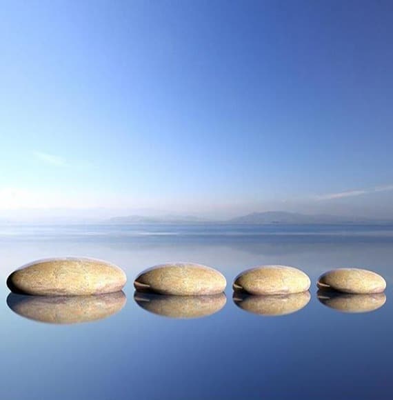 smooth rocks sitting atop calm waters.