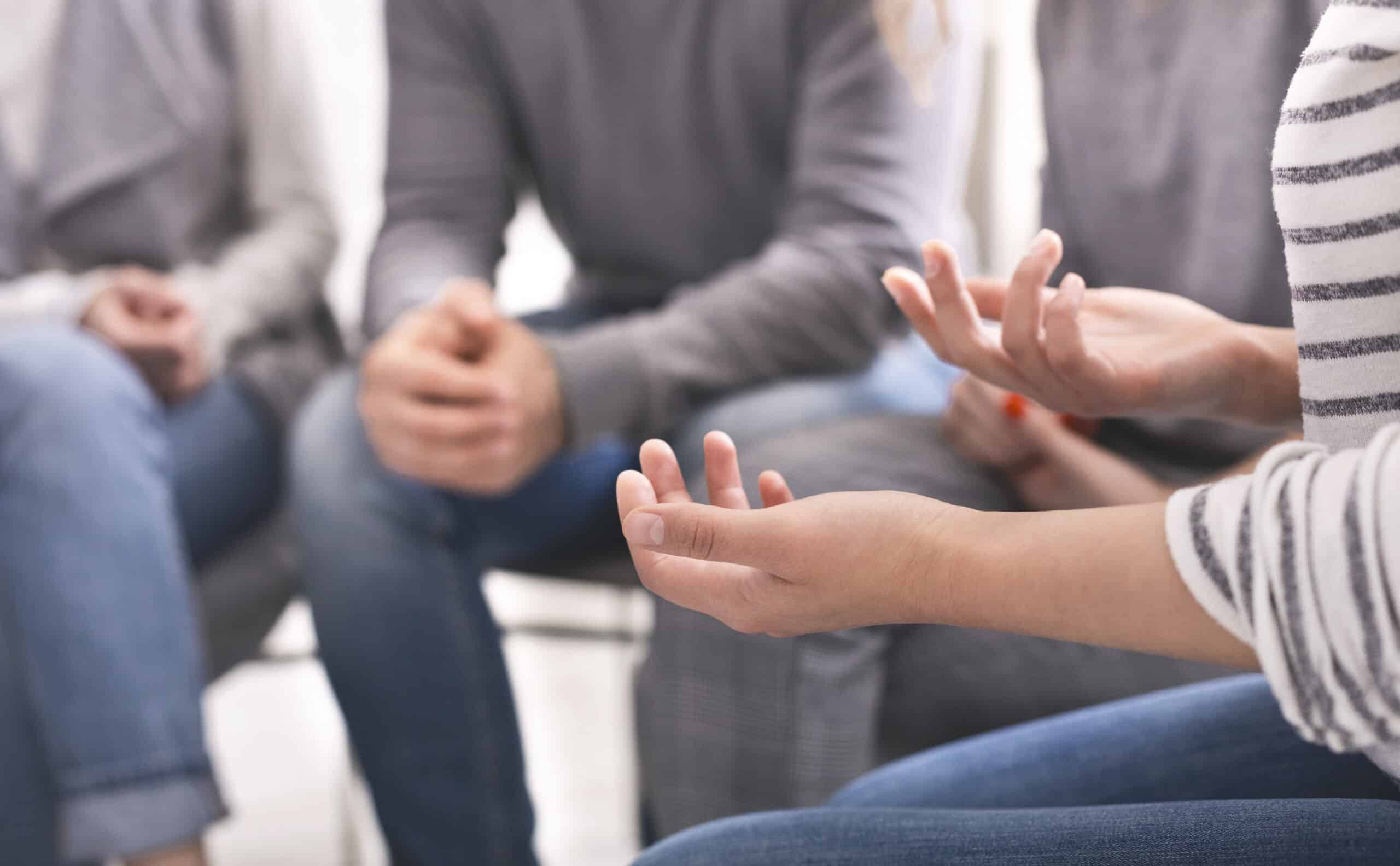 A close up of someone's hands in a group discussion