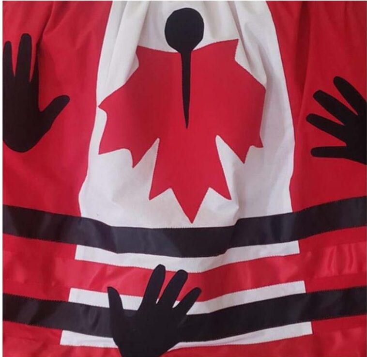 Black handprints on a Canadian Flag with a red and back band across it.