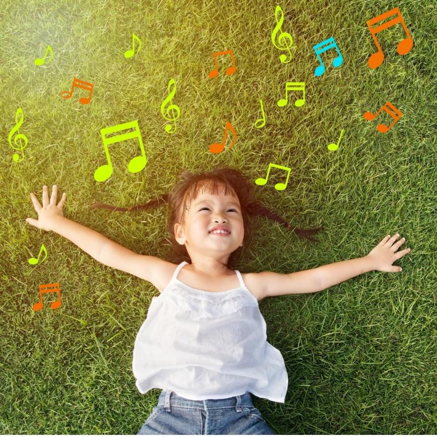 A little girl lays down on grass with music notes cascading by to promote Move and Groove.