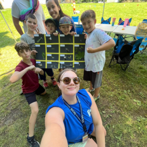 A HYPE Summer Camp Counsellor snaps a selfie with some campers.