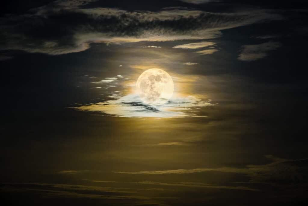 A photo of a very bright full moon on a cloudy night. Used to promote Full Moon Ceremony