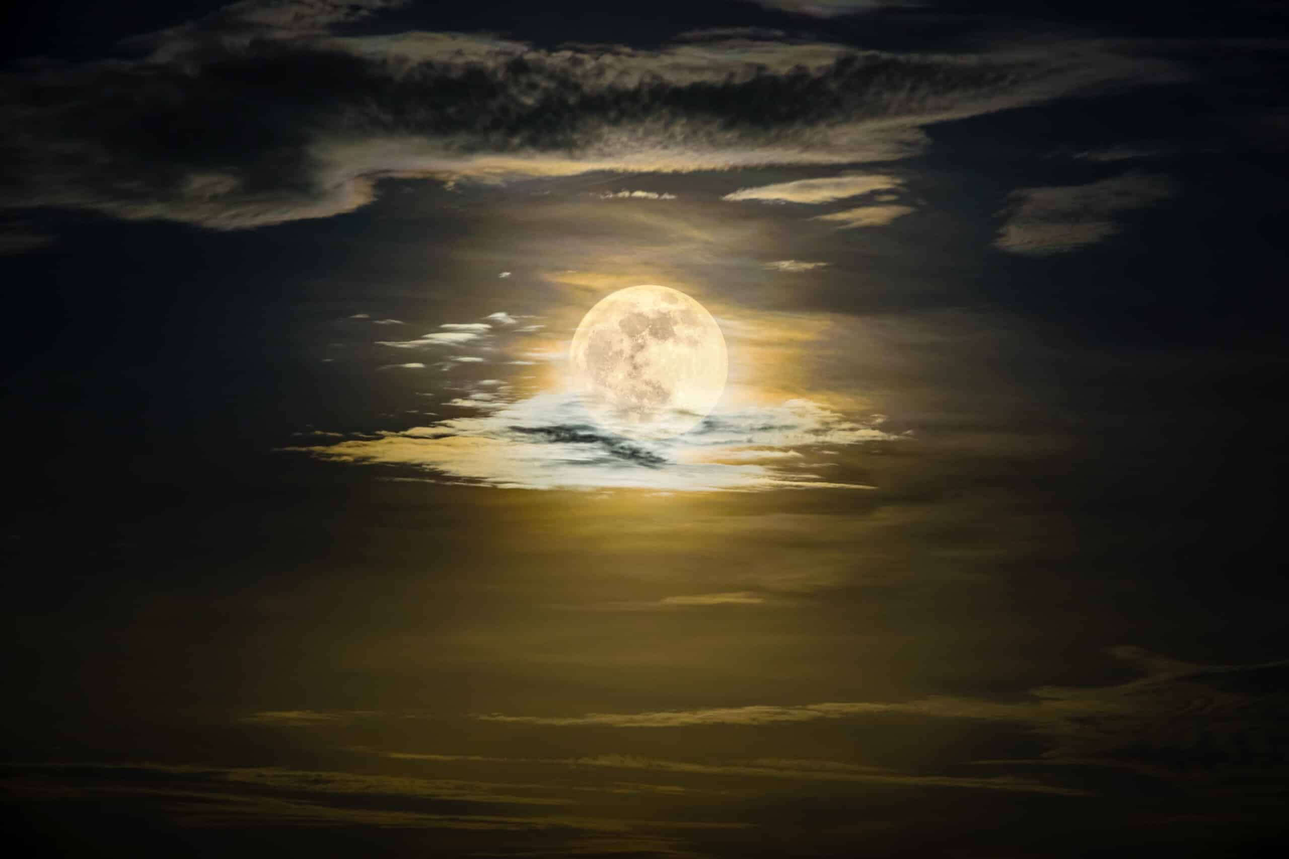 A photo of a very bright full moon on a cloudy night. Used to promote Full Moon Ceremony