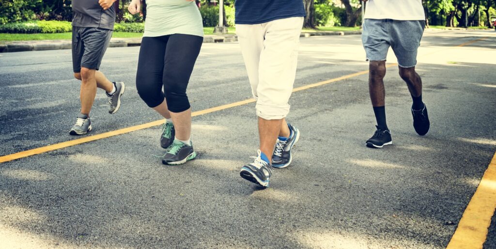 Close up shot of folks walking wearing running shoes. This photo is advertising the Diabetes Walking Group