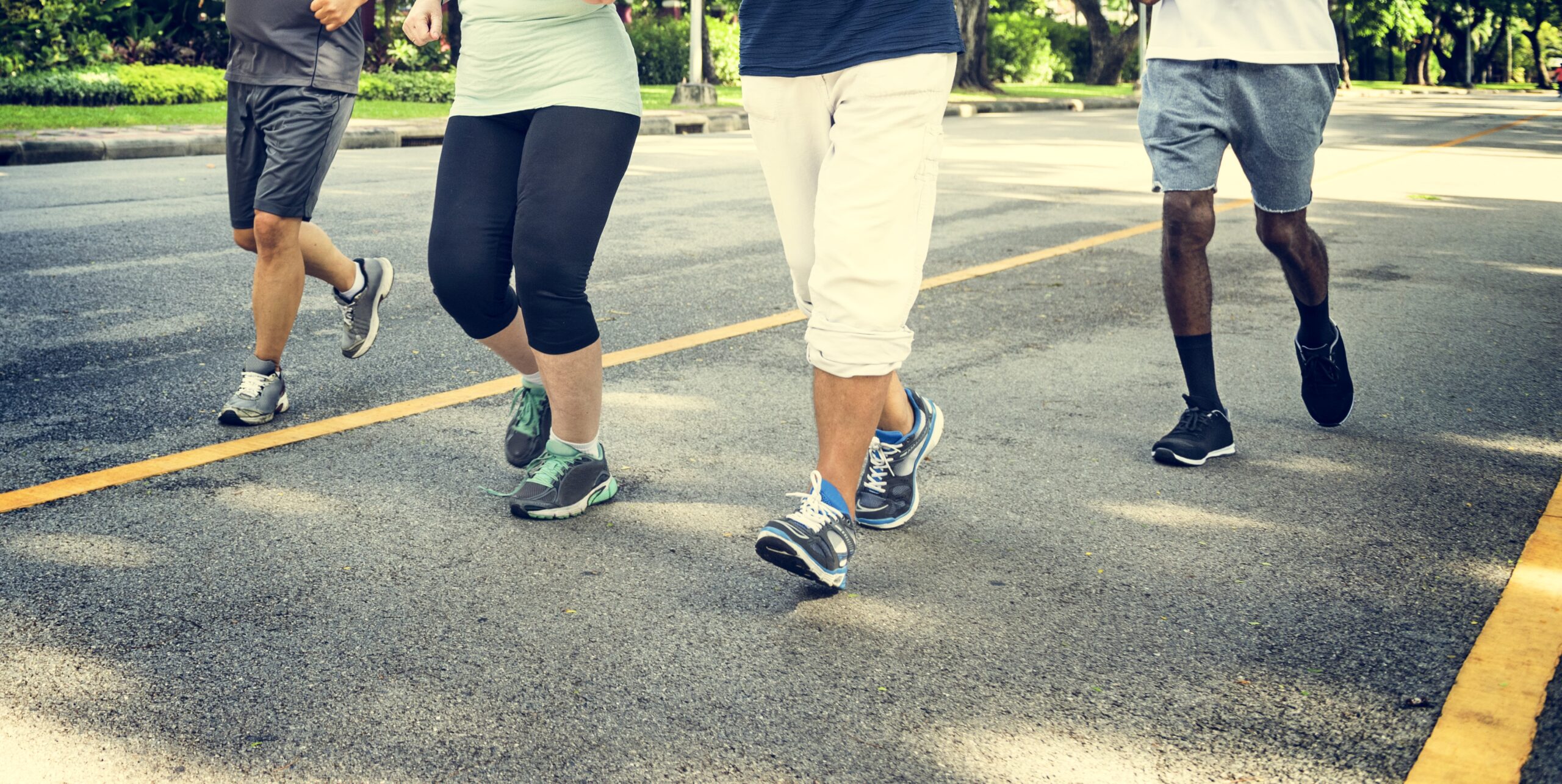 Close up shot of folks walking wearing running shoes. This photo is advertising the Diabetes Walking Group