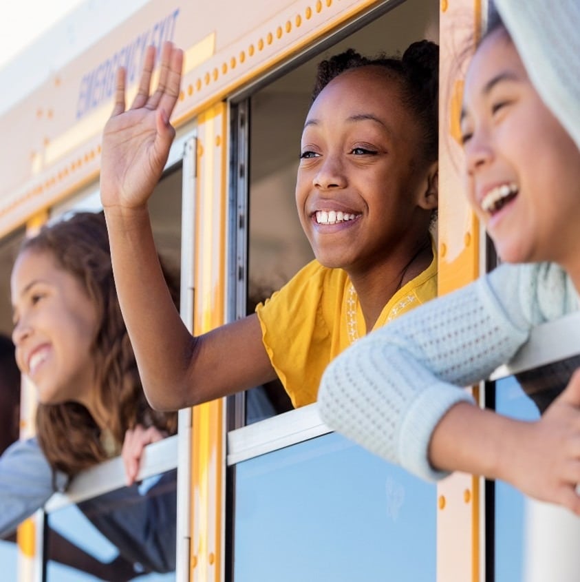 Children waiving from a school bus
